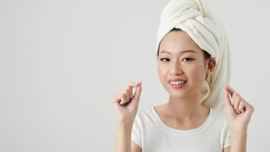 女子自行使用牙線嘗試清除牙垢